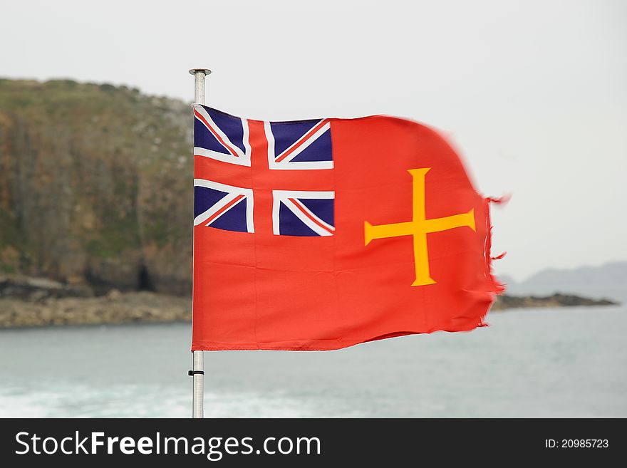 The golden cross on a red flag of the island of Guernsey merchant fleet. The golden cross on a red flag of the island of Guernsey merchant fleet.