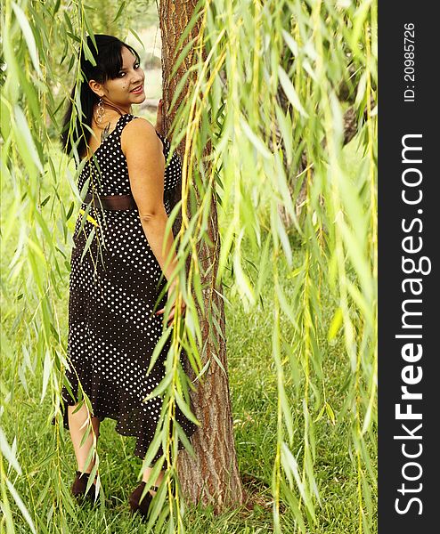 Portrait of a pretty woman posing under a weeping willow tree. Portrait of a pretty woman posing under a weeping willow tree.