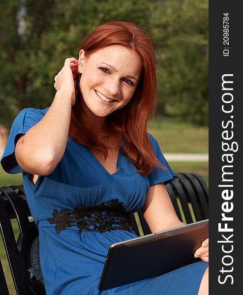 Pretty woman holding a tablet and smiling. Pretty woman holding a tablet and smiling.