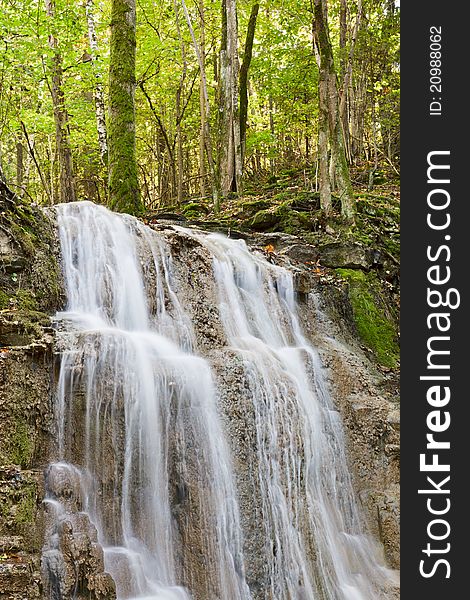 Waterfall with a stream in the deciduous forest