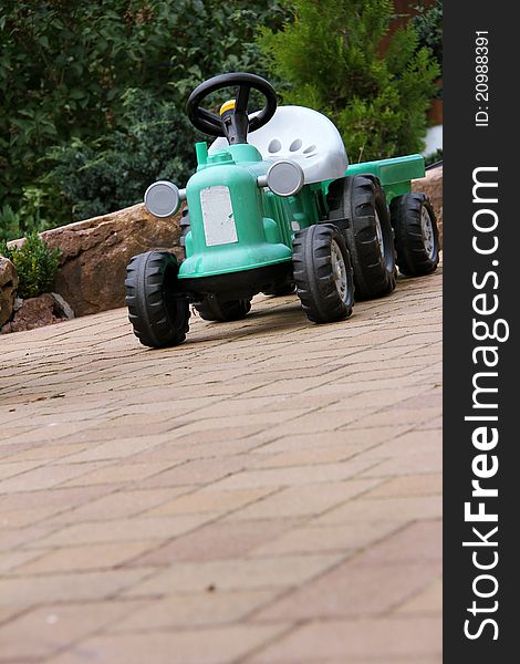 Green tractor toy on the garden terrace