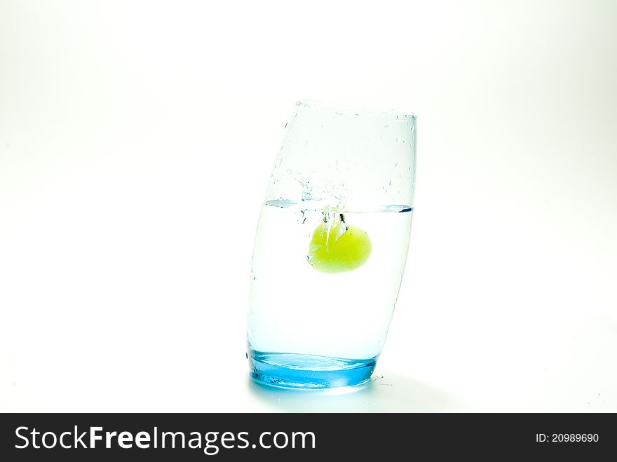 Grape splashing in a glass of water