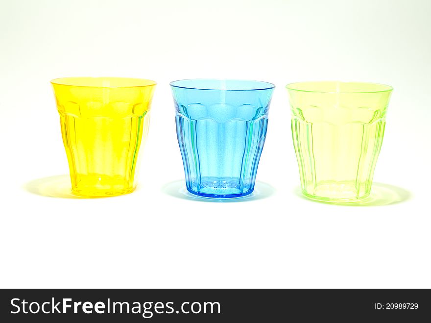 Three colourful glasses against a small background. Three colourful glasses against a small background