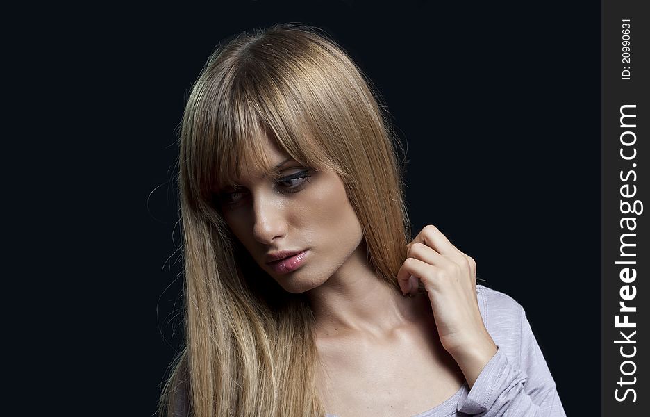 A portrait of a young blond woman isolated on black background. A portrait of a young blond woman isolated on black background