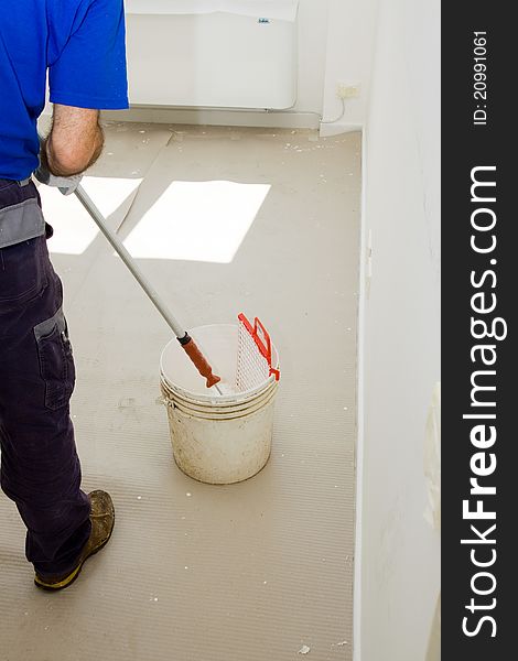 House painter using the roller for the walls of the room