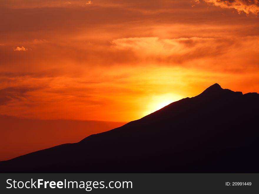 Clouded orange sky with mountain silhouette