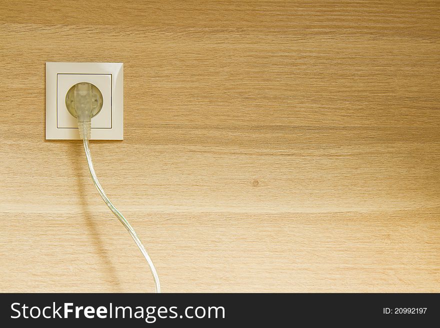 Electric plug in oak wooden wall background. Electric plug in oak wooden wall background