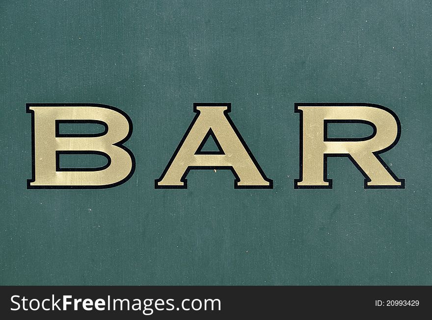 Golden Bar sign painted on green wall