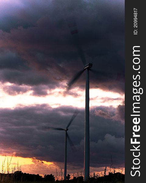 An image of wind turbine at the sunset