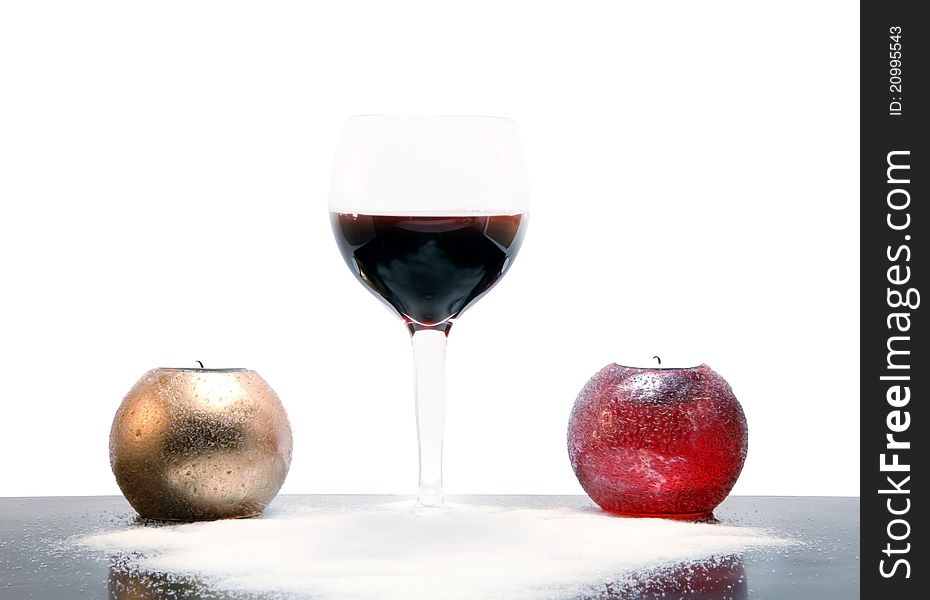 Glass of wine laying on white crystals of salt, with golden candle on the lef and red coloured candle on the right. Glass of wine laying on white crystals of salt, with golden candle on the lef and red coloured candle on the right