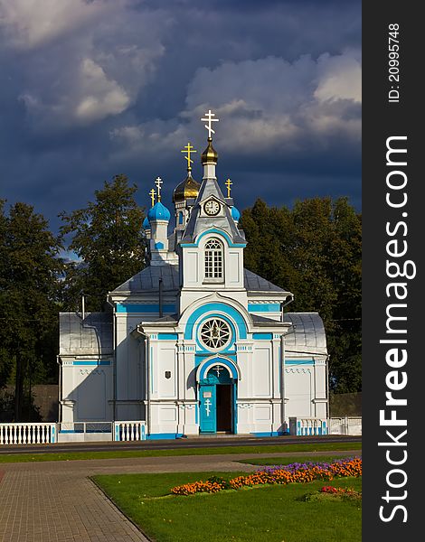 White orthodox church with gleaming crosses on a dark stormy sky