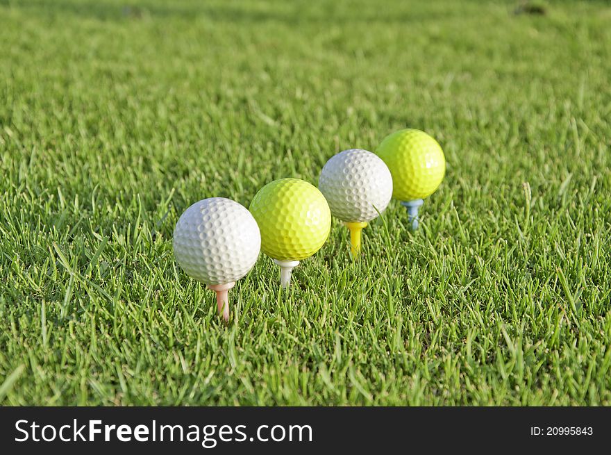 White and yellow balls of golf placed on his tees. White and yellow balls of golf placed on his tees.