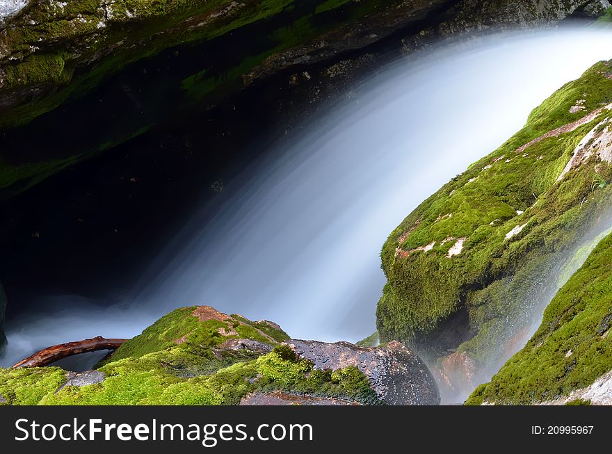 A slow motion blur waterfall over mossy stones. A slow motion blur waterfall over mossy stones.