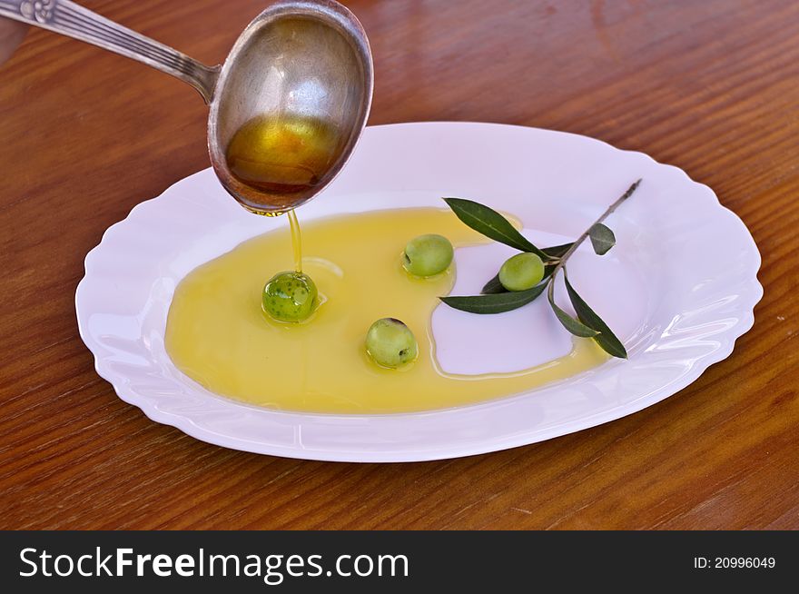 Olive branch with olive oil on a wooden background. Olive branch with olive oil on a wooden background