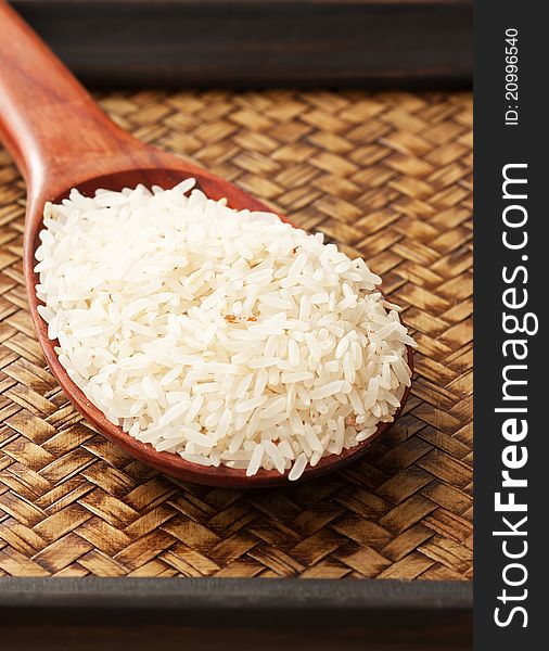 Color raw rice in spoonon wood tray