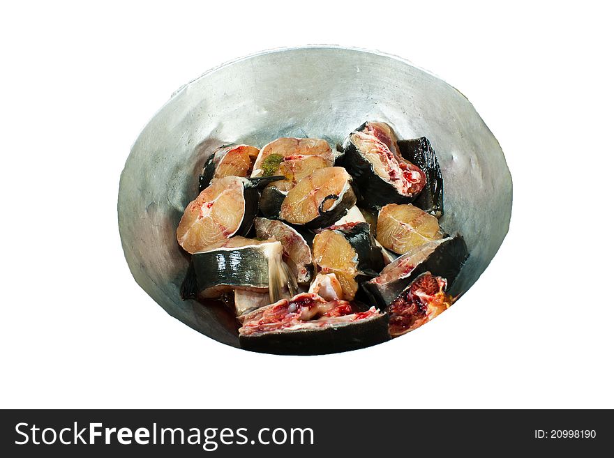 Fresh fish is cut into pieces in a stainless steel cup.