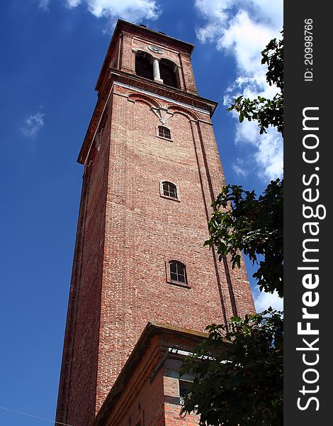 A bell tower of bricks on blue sky