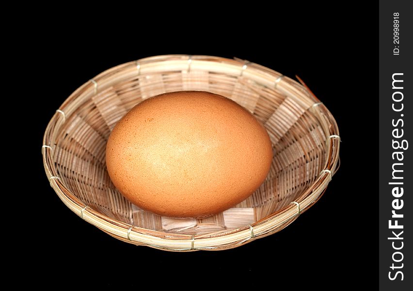 Egg in a basket on black background