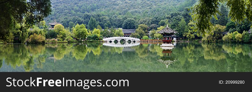 Chinese park,arch bridge and pavilion on pond