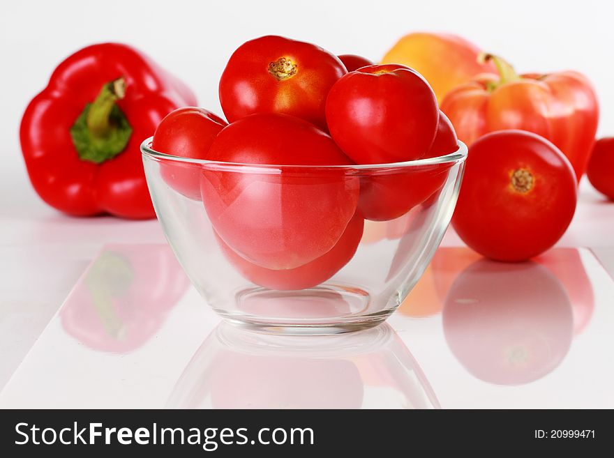 Tomatoes in a glass cup on the background of vegetables. Tomatoes in a glass cup on the background of vegetables.