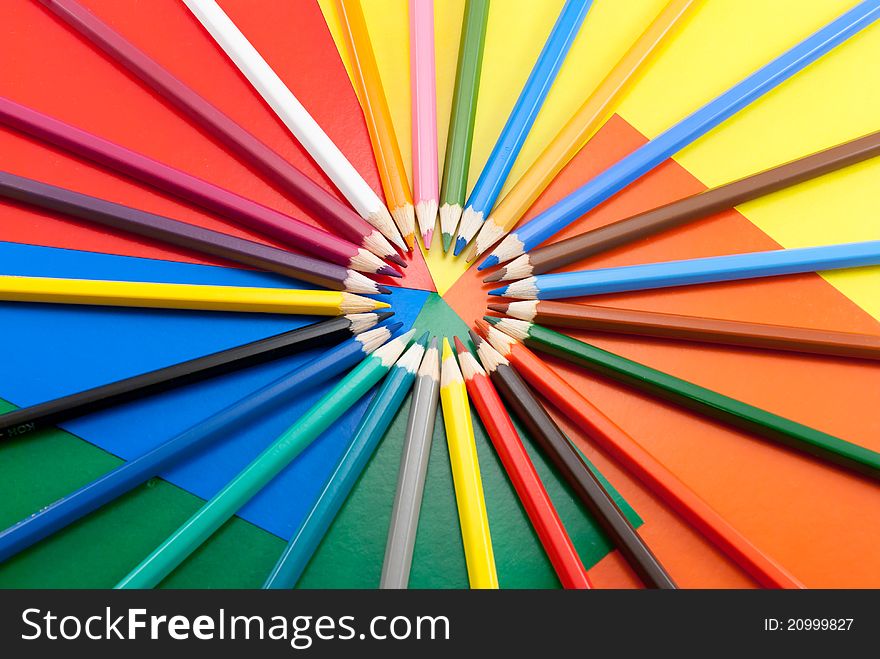 Multi-colored pencils lie on a color cardboard. Multi-colored pencils lie on a color cardboard