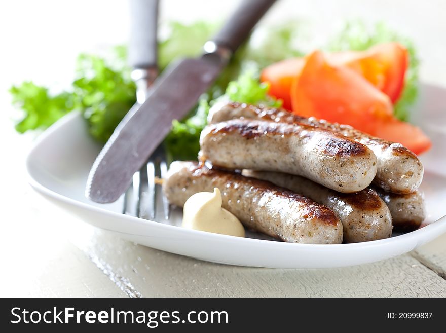 Fresh grilled sausages with salad on plate