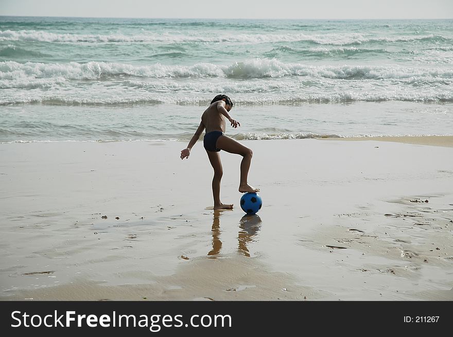 Young boy playing ball on the beach. Young boy playing ball on the beach