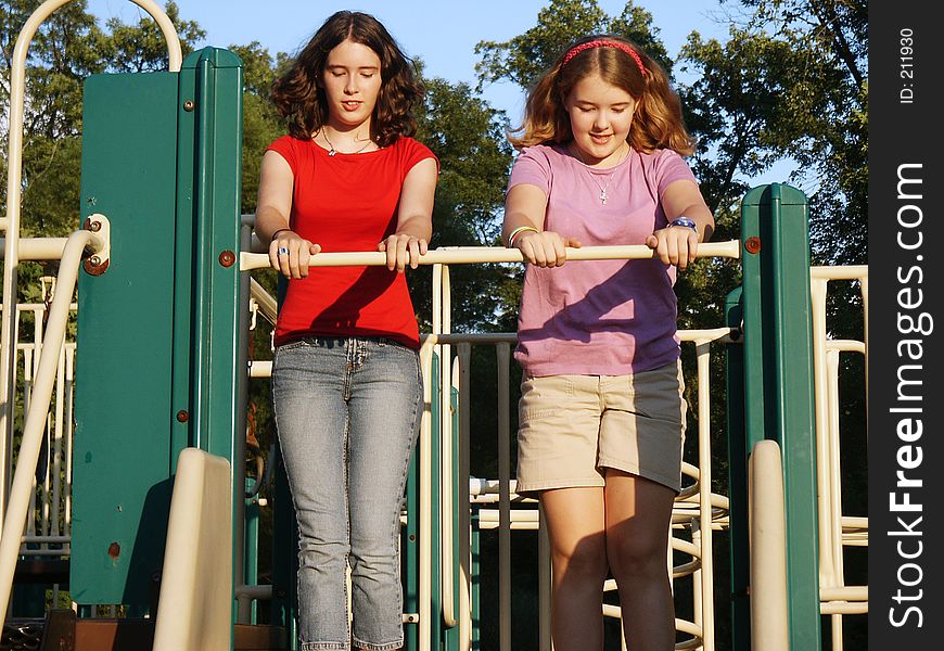 Teen sisters standing at the top of the slides. Teen sisters standing at the top of the slides