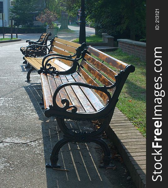 A trio of classic benches along a walkway