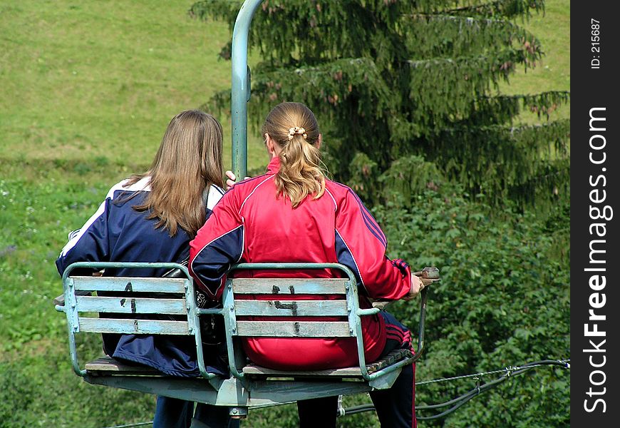 Two girls on a chair-lift in summer