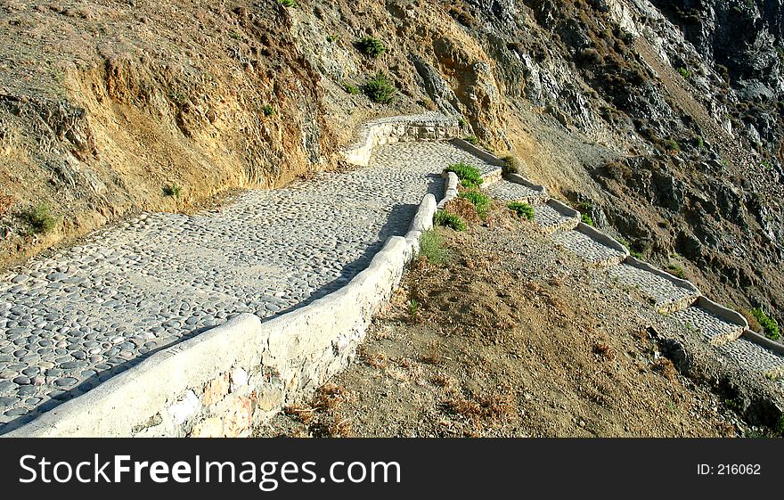 A stepped cobble-paved pathway going downhill. A stepped cobble-paved pathway going downhill