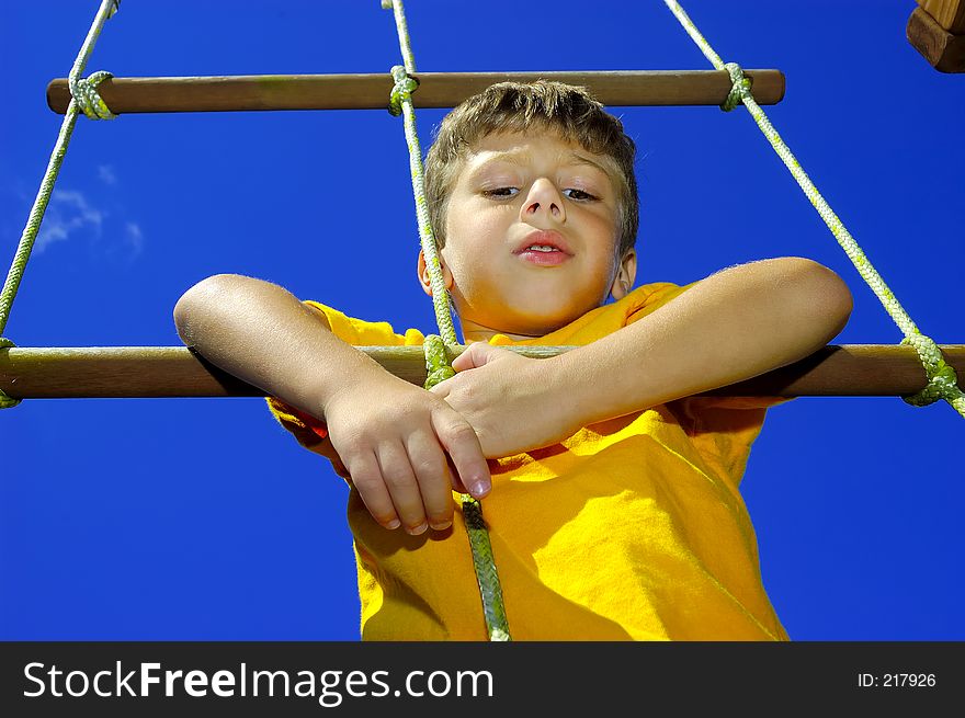 Young Boy Climbing a Rope Ladder. Young Boy Climbing a Rope Ladder.