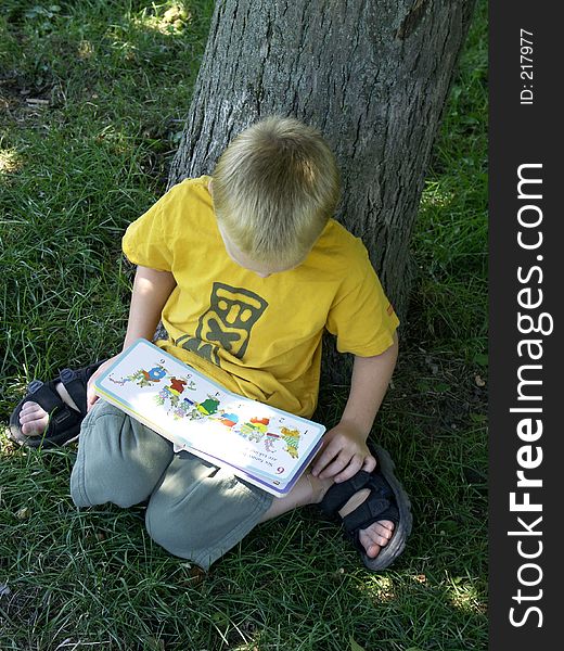 Five year old boy reading a book. Five year old boy reading a book