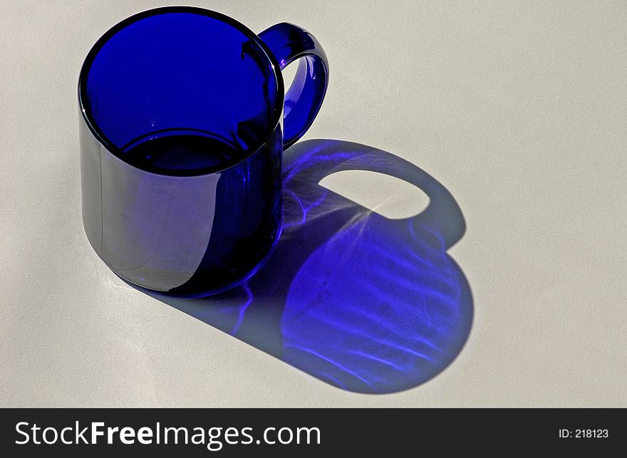 Bright blue coffee mug with reflected blue shadow