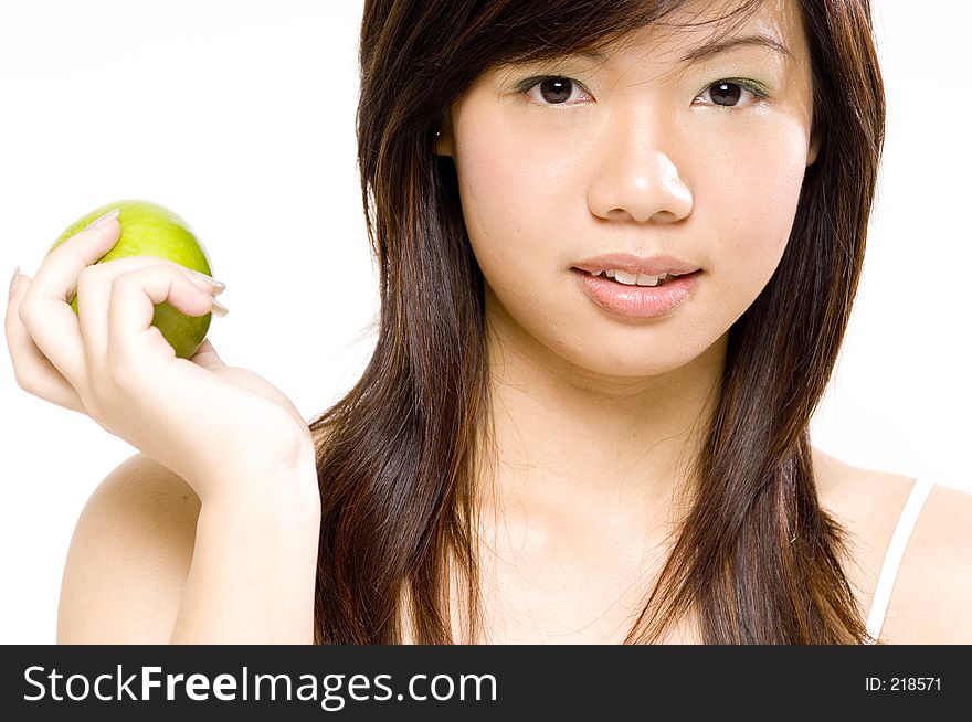 A pretty young asian woman holds an apple in her hand. A pretty young asian woman holds an apple in her hand