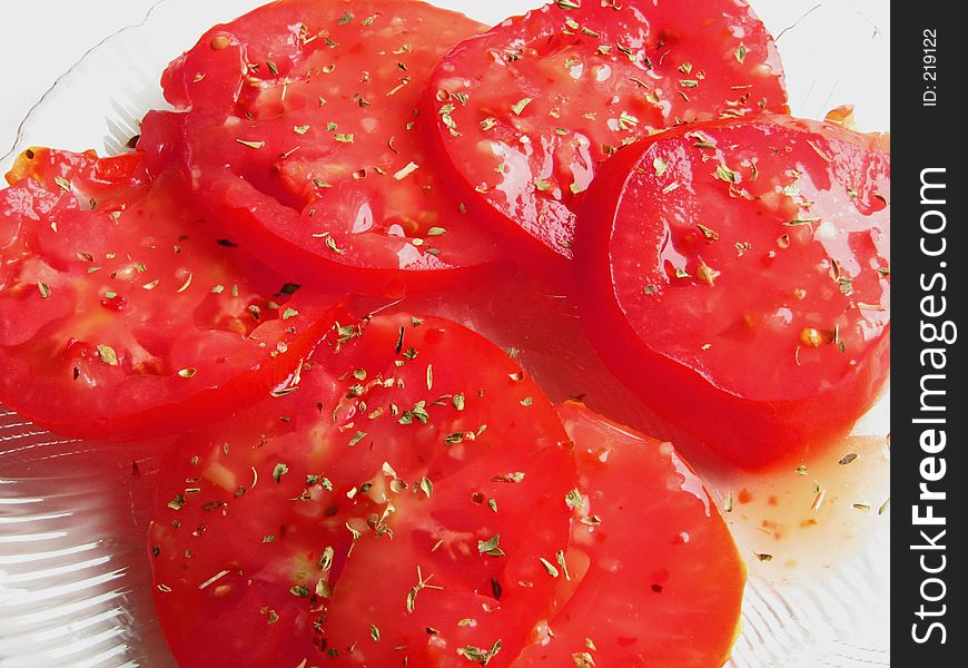 Sliced tomatoes with dressing, garnished with basil