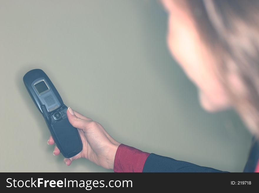 A young woman in a suit, takes a picture with a picture-phone. A young woman in a suit, takes a picture with a picture-phone.