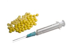 Syringe And Yellow Tablets Stock Photos