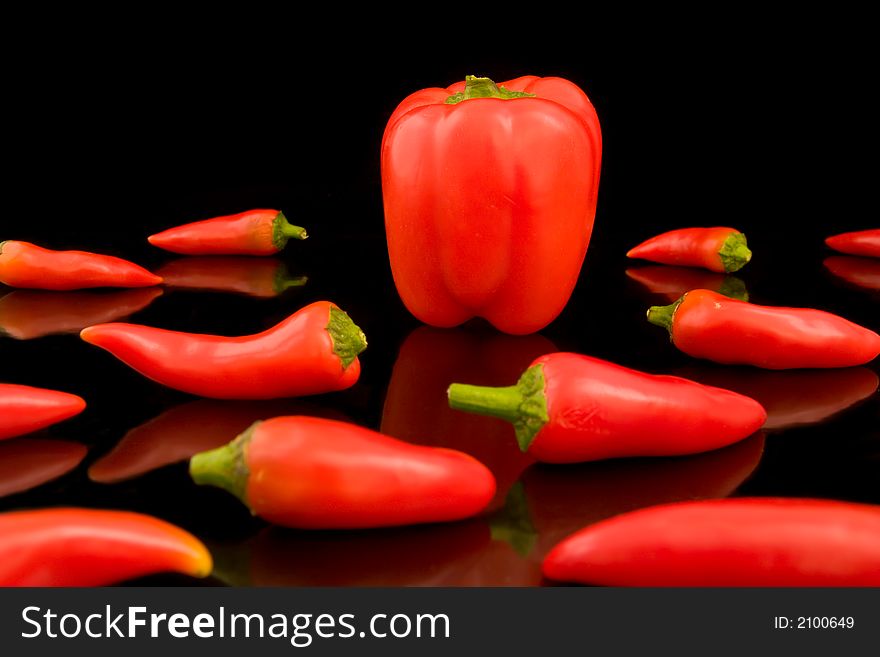 Chili and Bell Peppers reflecting in a black background. Chili and Bell Peppers reflecting in a black background.