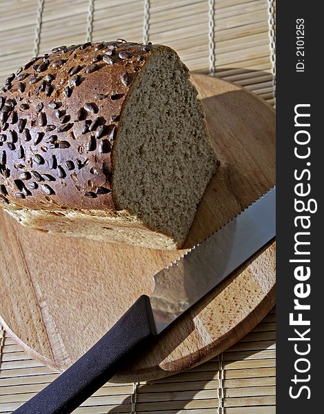 Whole grain bread on a wooden cutting board: healthy nutrition concept