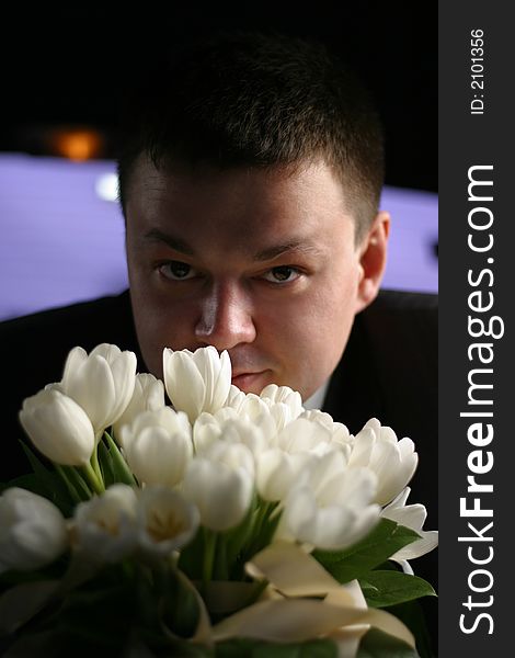 The groom with a bouquet from white tulips