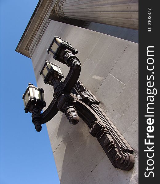 Old ornate decorative brass lamp with three heads on old building in London. Old ornate decorative brass lamp with three heads on old building in London