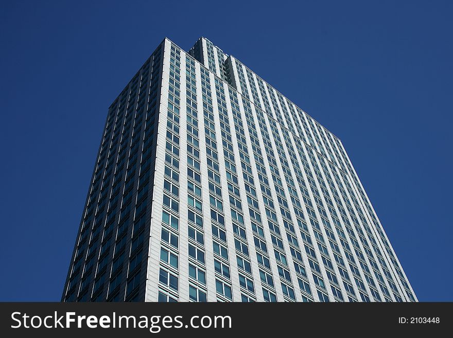 Top of the gray office building against the blue sky.