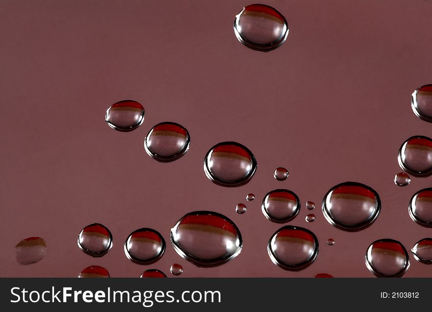 Water drops with red, black, and brown reflection