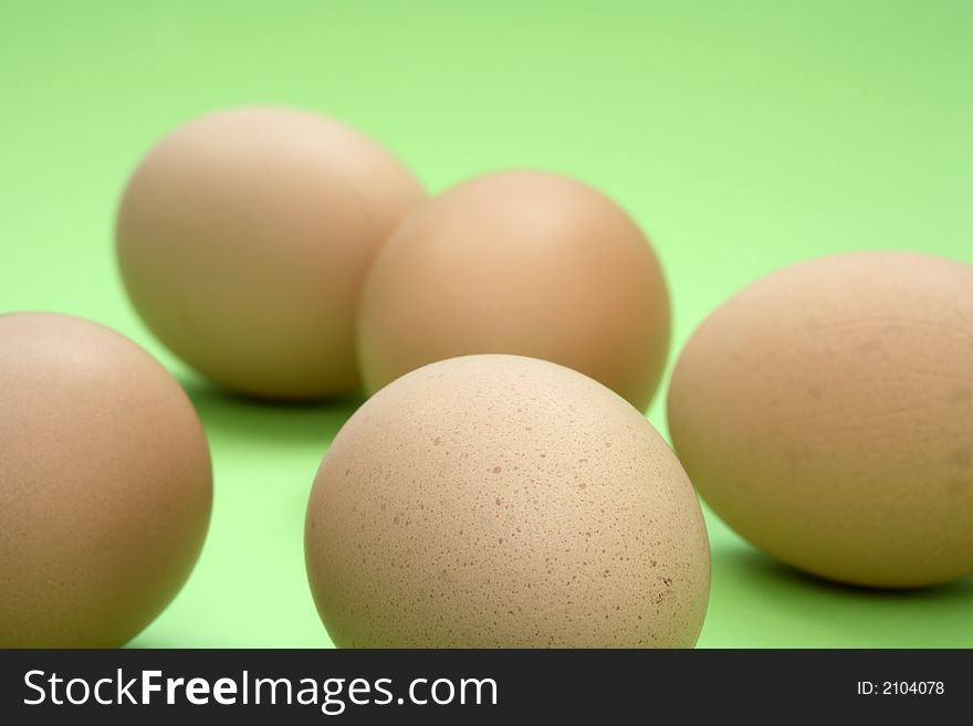 Some brown eggs and a green background