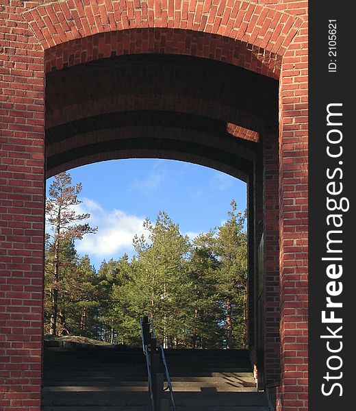 Red brick wall frame with blue sky and green trees. Red brick wall frame with blue sky and green trees