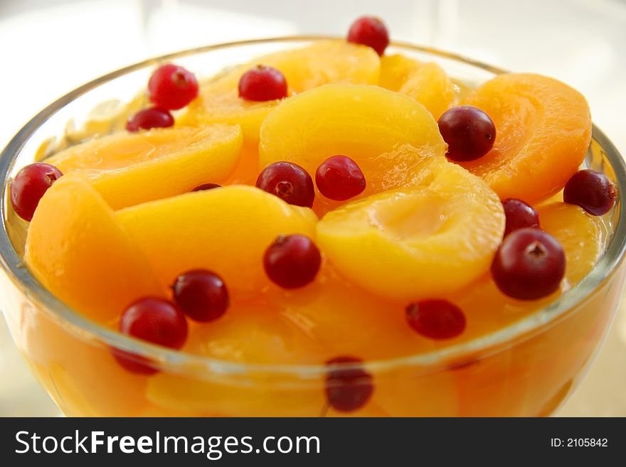 Juicy apricots with cranberries. Light background. Juicy apricots with cranberries. Light background.