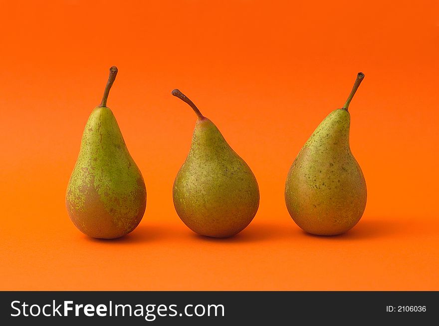 Three pears on orange background