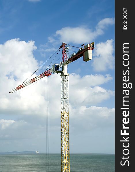 Tall crane doing high rise work near seafront