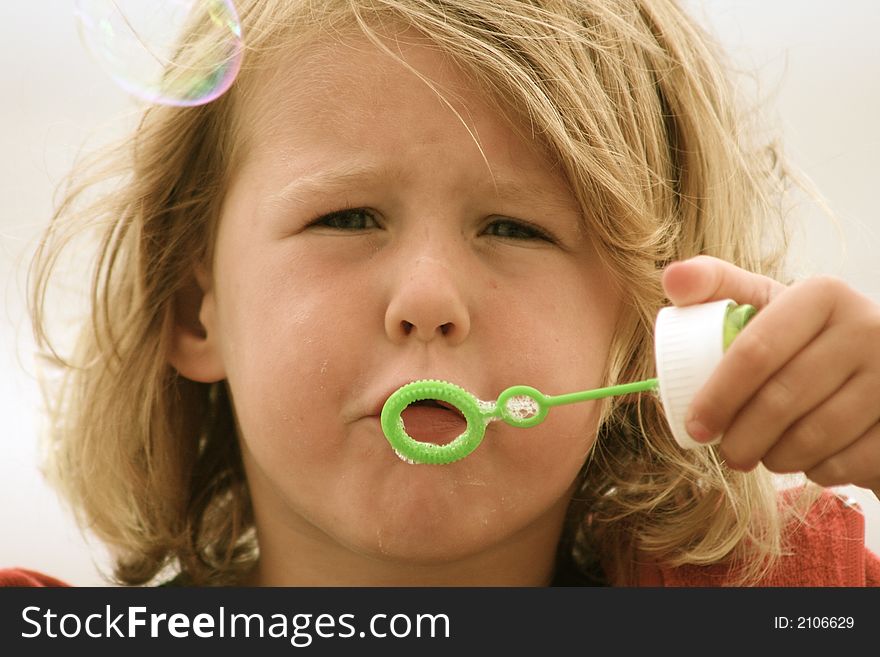 Kid blowing soap bubbles in the air